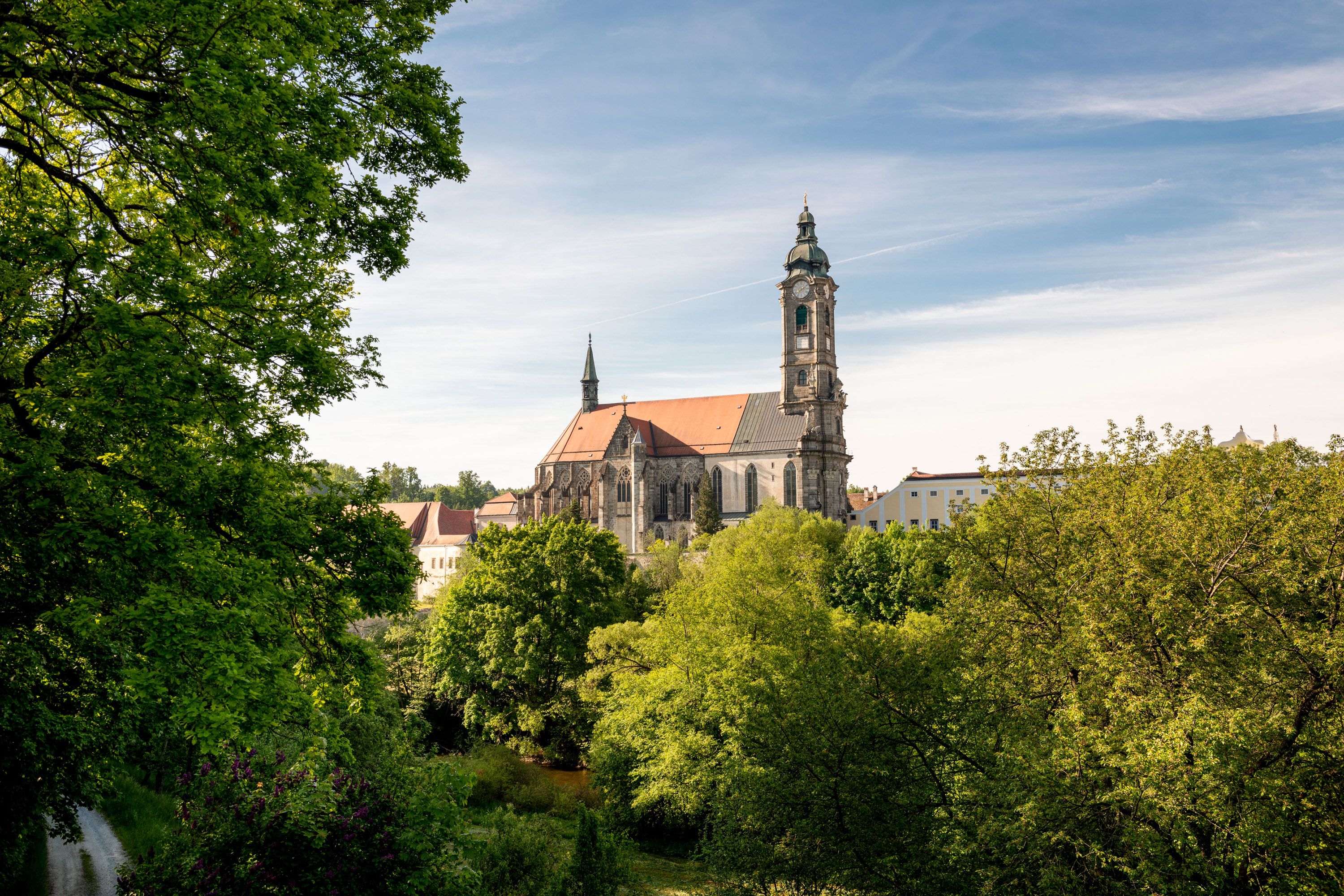 Kirche inmitten von Bäumen und blauem Himmel.