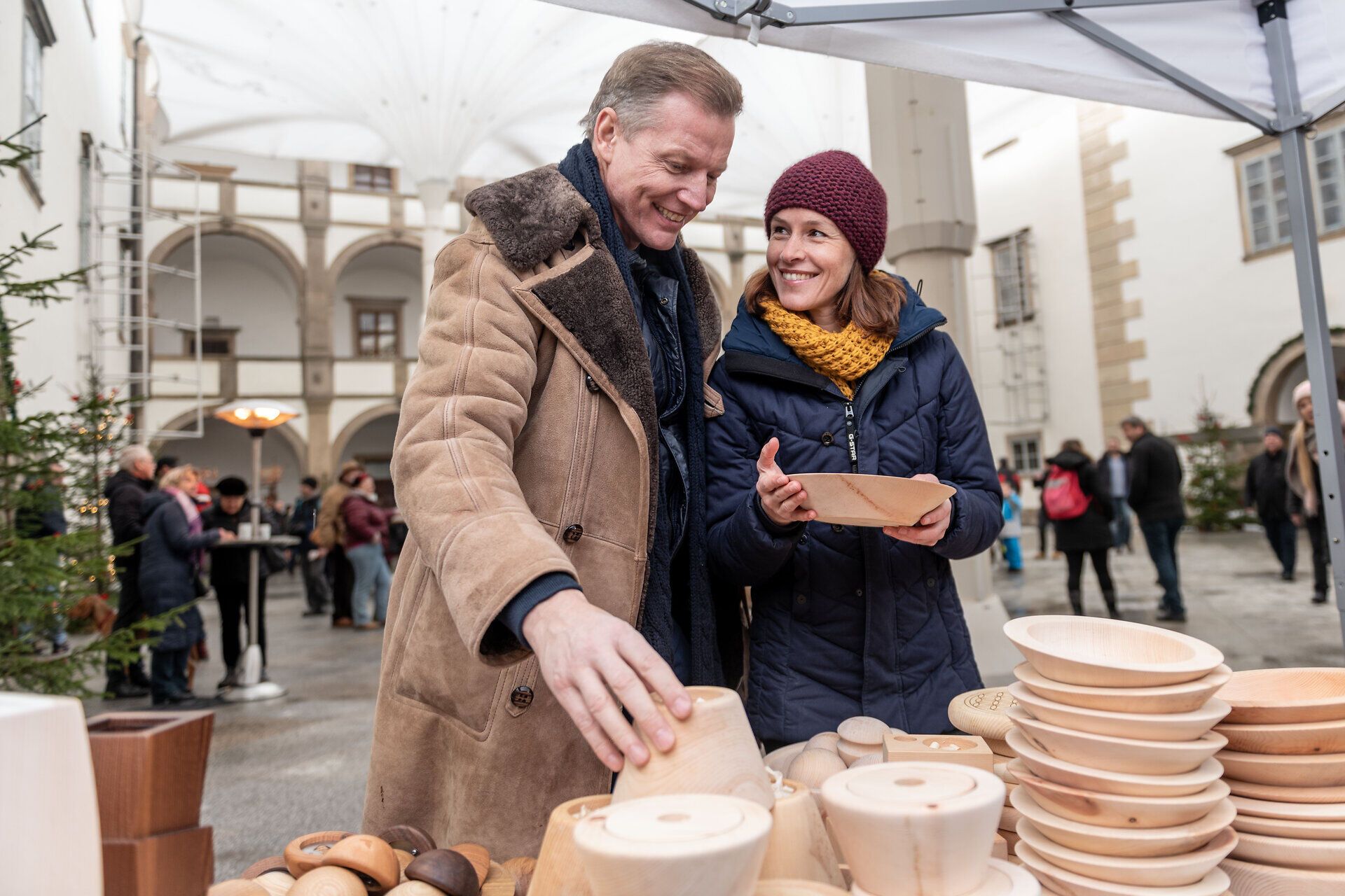 Inmitten der festlichen Atmosphäre des Adventmarktes strahlen die Augen der Besucher vor Freude, während sie handgefertigte Holzkunstwerke bewundern. Der Duft von frisch gebrannten Mandeln und Glühwein erfüllt die Luft und lädt zum Verweilen ein. Hier wird die Vorfreude auf Weihnachten spürbar.