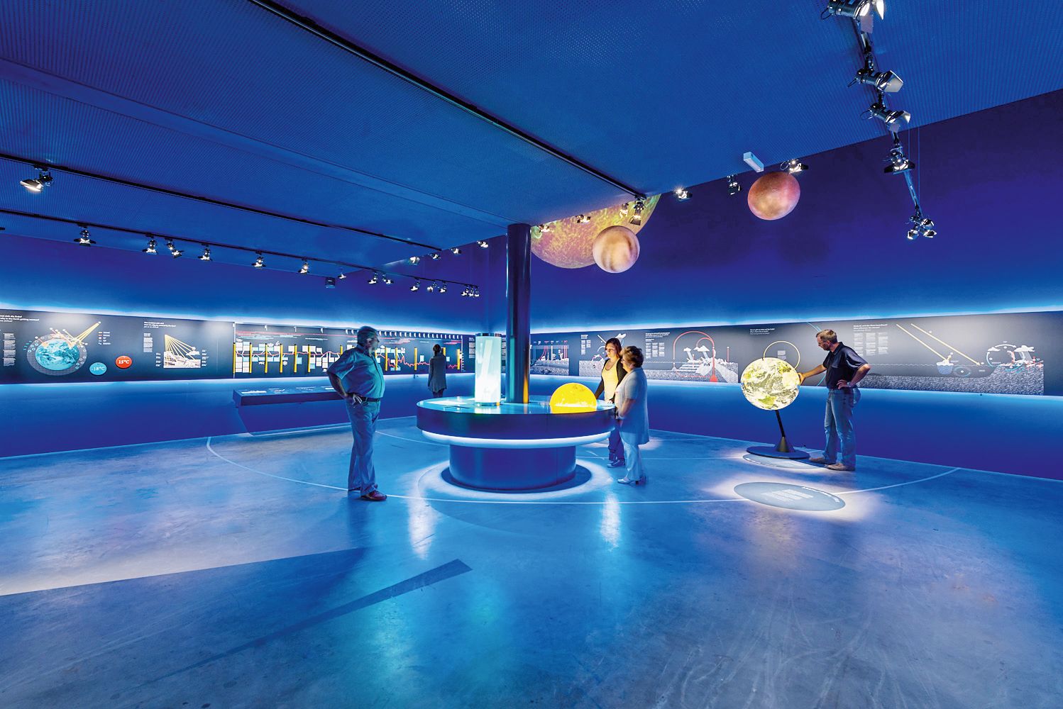 Innenansicht der Ausstellung SONNENWELT Großschönau mit blauer Beleuchtung und interaktiven Exponaten.