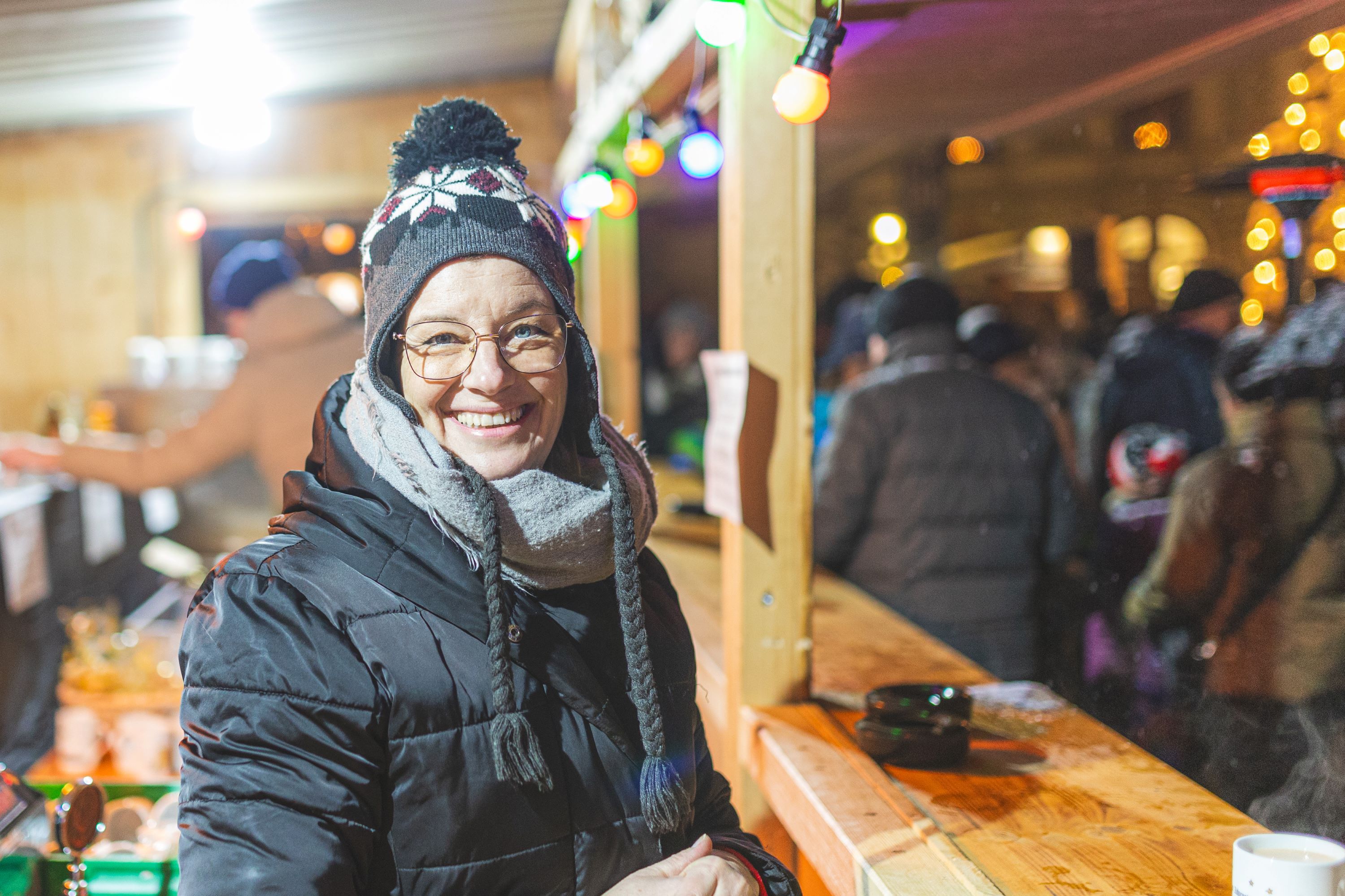 Weitraer Adventtage: eine Frau steht lächelnd vor einer Weihnachtshütte