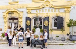 Eine Gruppe Kinder bei einer Stadtbesichtigung durch Weitra, vor der historischen Apotheke von Weitra.