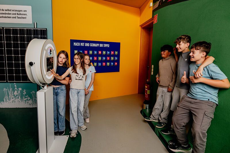 Gruppe von Jugendlichen interagiert der Fotobox vor einem Green Screen