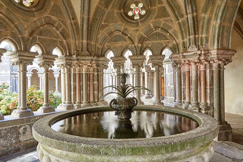 Ein Brunnen im Kreuzgang des Stifts Zwettl mit verzierten Säulen und einem gotischen Gewölbe.