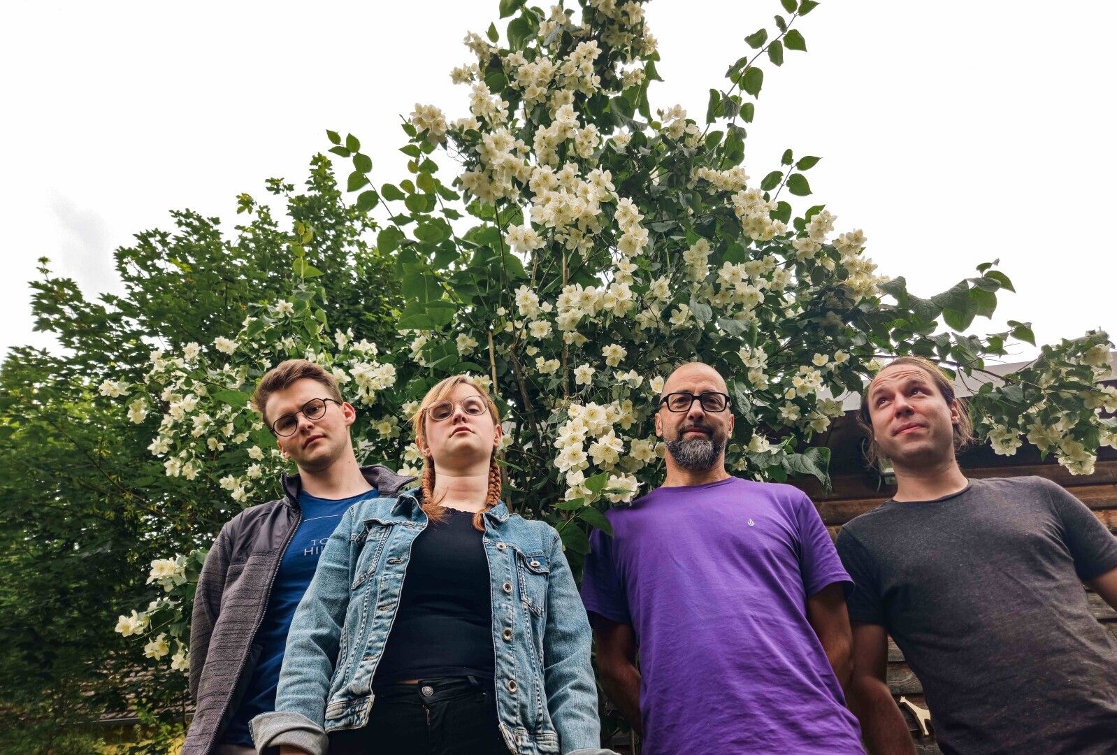 Eine Gruppe von Menschen, die unter einem Baum mit weißen Blumen stehen