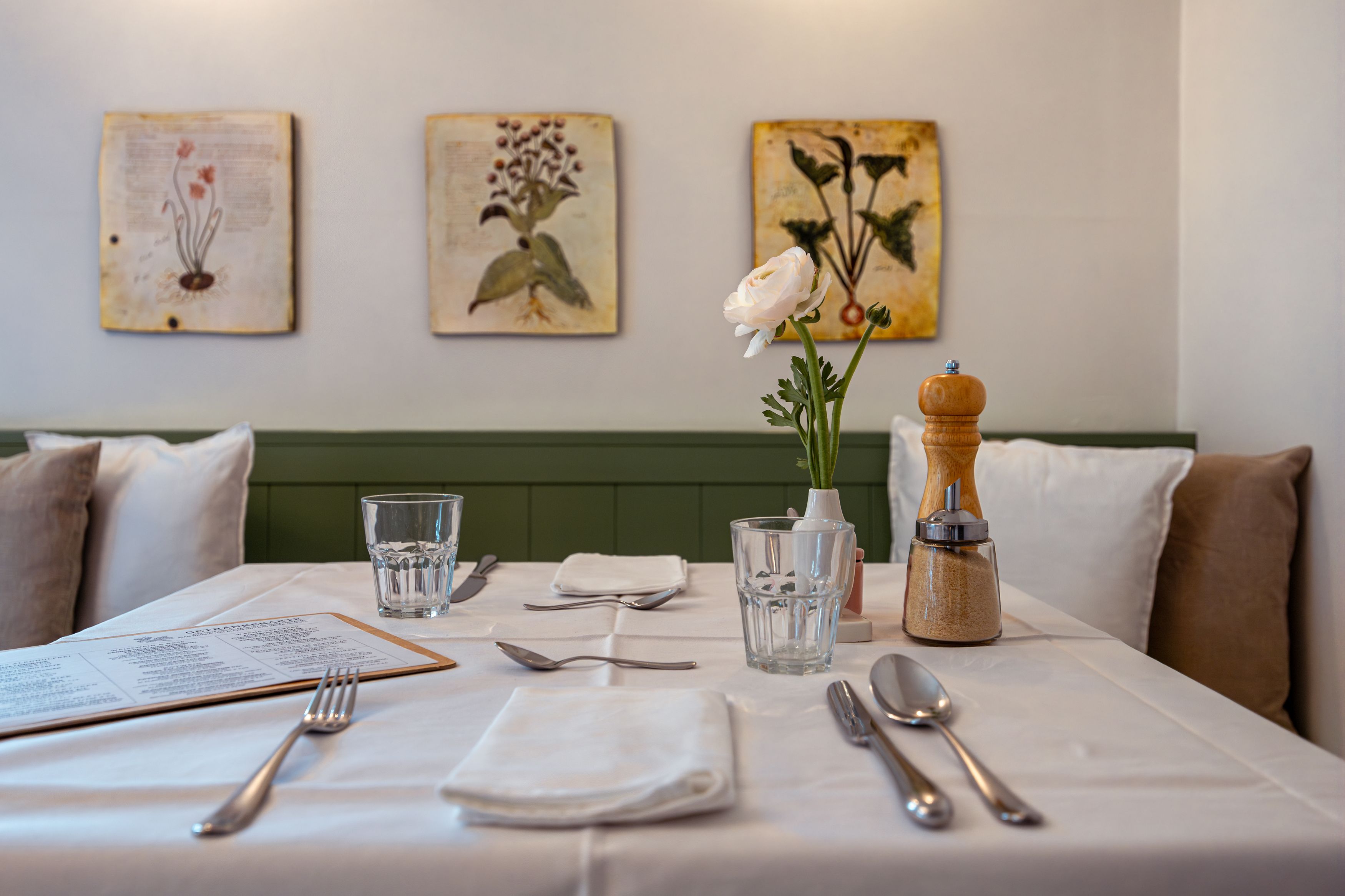 Ein gedeckter Tisch in einem Restaurant mit Blumen und Gewürzen.