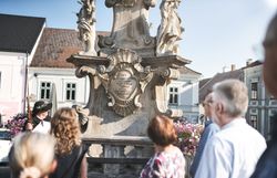 Der Nachtwächter zu Weitra und eine Gruppe Personen vor der Pestsäule in Weitra.