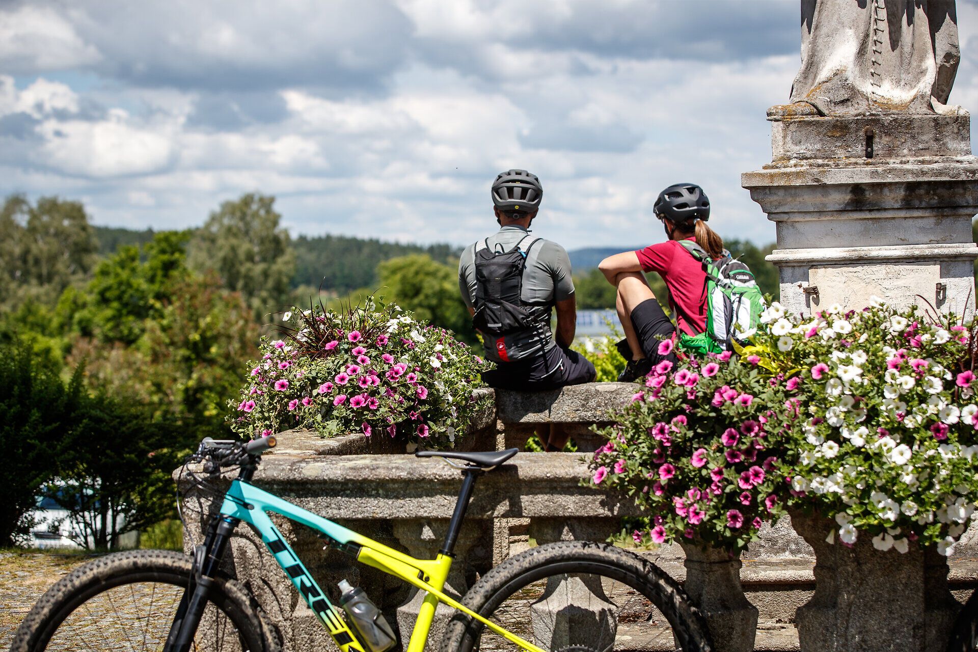 Inmitten einer blühenden Landschaft genießen zwei Mountainbiker eine wohlverdiente Pause. Umgeben von bunten Blumen und der frischen Bergluft, bietet dieser Ort eine perfekte Kulisse für Abenteuer in der Natur.